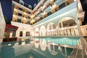 a large building with a swimming pool in front of it at Solar Hotel in Siem Reap