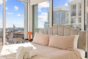 białe łóżko w pokoju z dużym oknem w obiekcie @ Marbella Lane - Modern 1BR Gem in Long Beach w mieście Long Beach