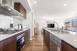 eine große Küche mit Spüle und Herd in der Unterkunft Point Cook's Spacious and Comfy 4BR/3BA Haven! in Point Cook
