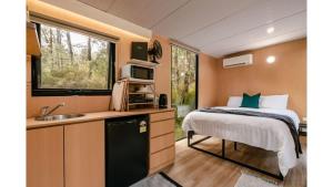 1 dormitorio con 1 cama y cocina con fregadero en Quantum Field en Toolangi