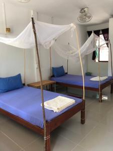 a room with three beds with a canopy at Mangrove Beach Bungalows in Koh Rong Sanloem