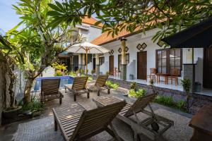 a group of chairs and tables in front of a building at Widia Homestay Nusa Lembongan in Nusa Lembongan