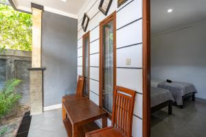 a room with a bench and a table and a chair at Widia Homestay Nusa Lembongan in Nusa Lembongan
