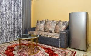 sala de estar con sofá y nevera en Qwetu Homes, en Keruguya