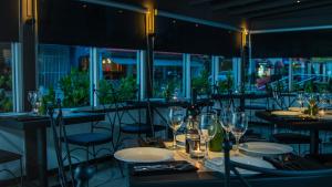 un restaurant avec des tables et des chaises et des verres à vin dans l'établissement Casa Condado Residences & Hotel Rooms, à San Juan