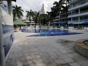 una gran piscina con sillas y un edificio en APARTAMENTO CAMPESTRE CHINAUTA, en La Serena