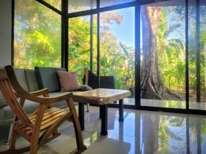 プエルト・ヒメネスにあるLuba houseのベンチ、テーブル、大きな窓が備わる客室です。 +7枚の写真