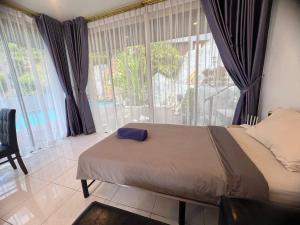 a bedroom with a bed and a large window at Blue Sky Villa in Karon Beach