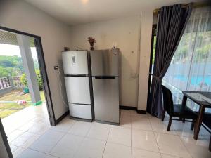 uma cozinha com um frigorífico, uma mesa e uma janela em Blue Sky Villa em Praia de Karon