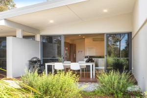 una casa con puertas de cristal, mesa y sillas en Eight Willows Retreat en Margaret River Town