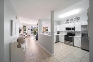 an open kitchen with white cabinets and appliances and a living room at Gulfside 210 - 2BR plus bunkroom with Ocean & Pool Views in Fort Walton Beach