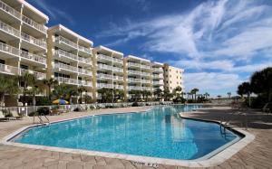 a swimming pool in front of a large apartment building at Gulfside 210 - 2BR plus bunkroom with Ocean & Pool Views in Fort Walton Beach