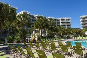 a row of lawn chairs next to a swimming pool at Gulfside 210 - 2BR plus bunkroom with Ocean & Pool Views in Fort Walton Beach