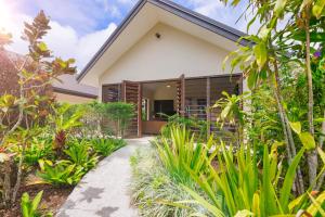 een huis met een tropische tuin en een loopbrug bij Mangoes Resort in Port Vila