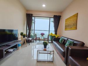 a living room with a couch and a television at Kensington Sunrise sg, Palas Horizon,kea farm in Brinchang
