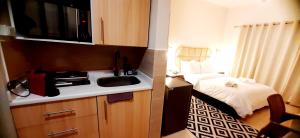 a small kitchen with a sink and a bed at Aldau heights Kevin in Hurghada