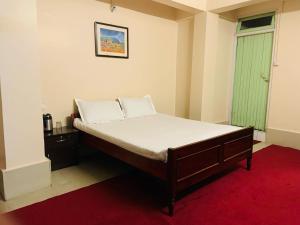 een slaapkamer met een bed en een groen raam bij OYO Flagship Hotel West End in Darjeeling