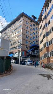 a large building with people walking in front of it at Cozy Condo near Burnham in Baguio