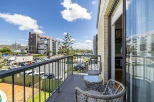 a balcony with two chairs and a view of a city at NEW! Breezy, Stylish 3BR Southport Oasis! in Gold Coast