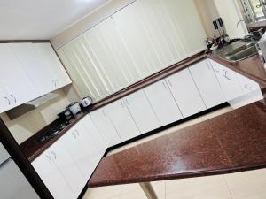 a kitchen with white cabinets and a brown counter top at Paradise Apartment Suva in Suva