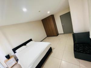 a small bedroom with a bed and a chair at Paradise Apartment Suva in Suva