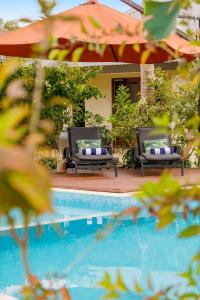 um par de cadeiras sentadas ao lado de uma piscina em Mangoes Resort em Port Vila