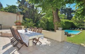 un patio con tavolo, sedie e piscina di Gorgeous Home In Aix En Provence With Kitchen a Les Figons