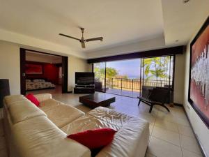 a living room with a couch and a large window at Ocean view apartment at Las Vistas Nativa Resort in Puntarenas