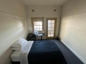 a bedroom with a bed and a desk in it at Coffs Harbour Hotel in Coffs Harbour