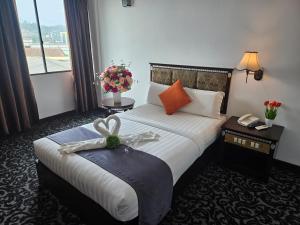 a hotel room with a bed with a bow on it at Go Lodge Hotel Kuantan in Kuantan