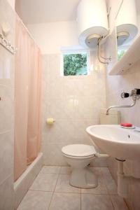 ein weißes Bad mit einem WC und einem Waschbecken in der Unterkunft Holiday home Paulo3 - close to the sea in Rogačić