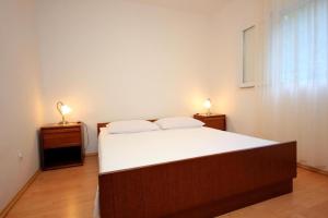 ein Schlafzimmer mit einem Bett und zwei Lampen an Nachttischen in der Unterkunft Holiday home Paulo3 - close to the sea in Rogačić