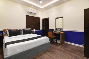 een slaapkamer met een bed, een bureau en een spiegel bij OYO Hotel sakina in Calcutta