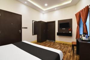 a hotel room with a bed and a tv at OYO Hotel sakina in Kolkata