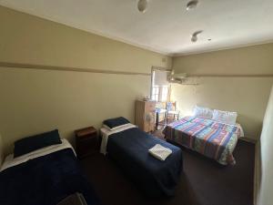 a small room with two beds and a window at Coffs Harbour Hotel in Coffs Harbour