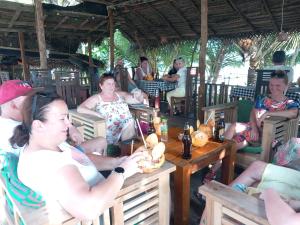 a group of people sitting at tables in a restaurant at Blue Horizon Beach Hotel in Tangalle