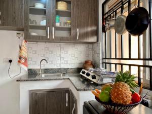 a kitchen with a bowl of fruit on the counter at The Lovely Homestay in Kampala