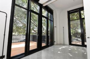 an empty room with large windows and a wooden deck at WRIGLEY'S GUM FACTORY LUXURY CONVERSION in Sydney