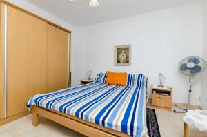 Schlafzimmer mit einem Bett mit blau-weiß gestreifter Bettwäsche in der Unterkunft Rooms Miho - close to the sea in Vrboska