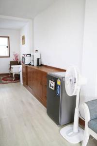 a room with a refrigerator and a desk with a fan at Happyhouse Laksi station (PK14) in Lak Si