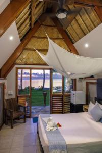 a bedroom with a bed and a large window at Mango Bay Resort in Namatakula