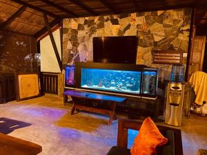uma sala de estar com um aquário e uma mesa em Sunrise Udawalawe Resort em Udawalawe