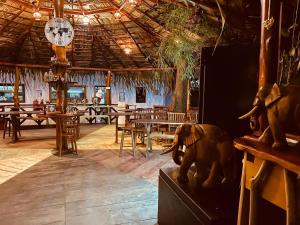 a restaurant with a clock on the ceiling and tables at Sunrise Udawalawe Resort in Udawalawe