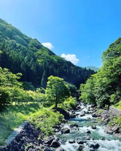 un río en medio de un valle con árboles en MONJUNO FUKUCHI en Kamikishida