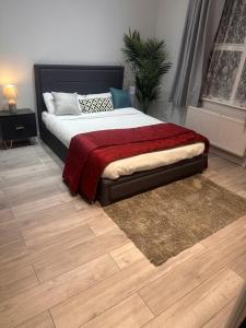 a bedroom with a bed with a red blanket at Paradise Vuze in Tilehurst