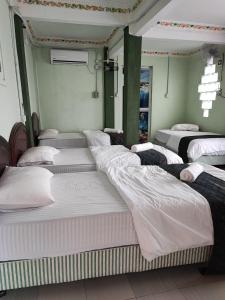 - un groupe de lits dans une chambre dans l'établissement Perhentian Chomel Chalet, aux Îles Perhentian
