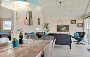 a kitchen and living room with a large wooden table at Lovely Home In Bogense With House Sea View in Bogense