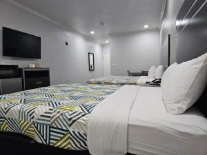 a hotel room with two beds and a flat screen tv at Motel 6 Houston, TX - Hwy 249 and Fallbrook in Houston