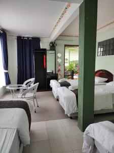 Zimmer mit 4 Betten, Tisch und Stühlen in der Unterkunft Perhentian Chomel Chalet in Perhentian Island