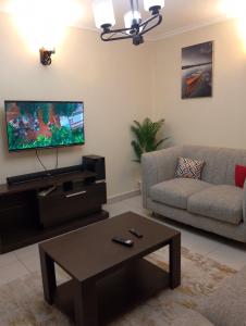 a living room with a couch and a flat screen tv at Sweet Homes Ngong Road in Nairobi